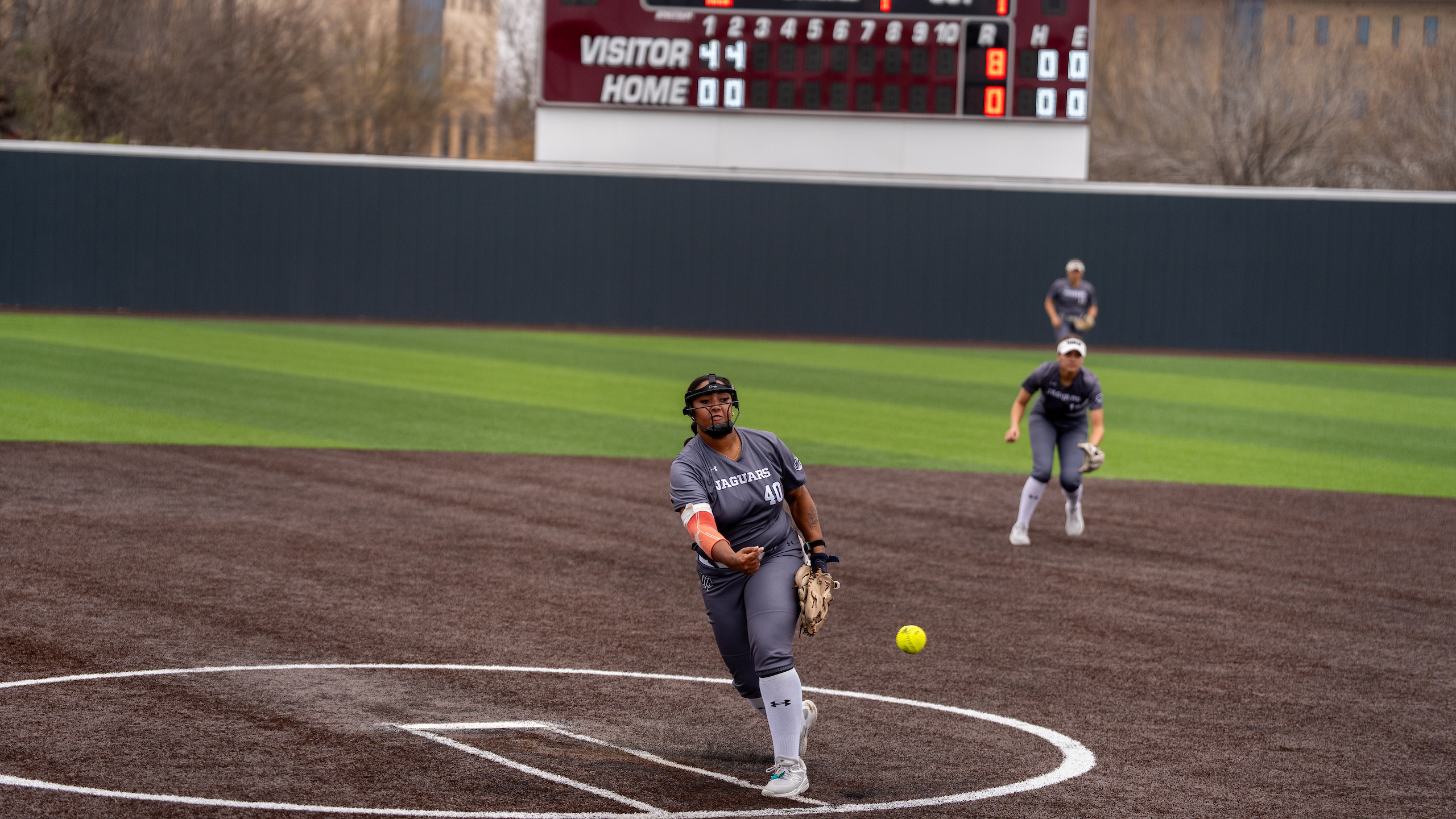 Softball pitcher, throing the softball toward the batter.