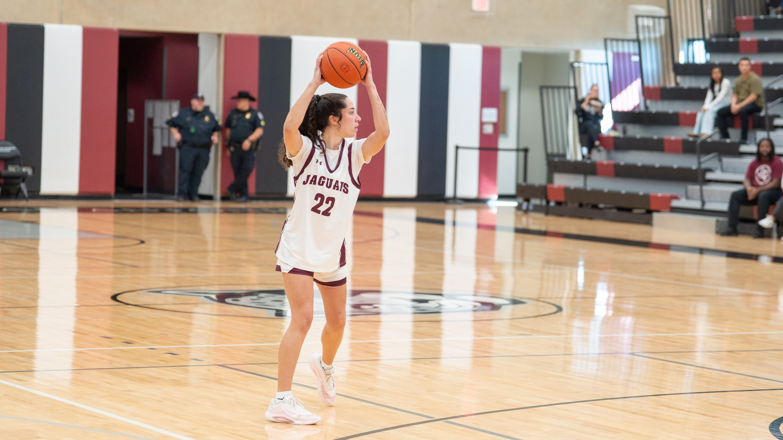 Women's basketball player with jersey number 22 holding the ball and looking for an opportunity to score.