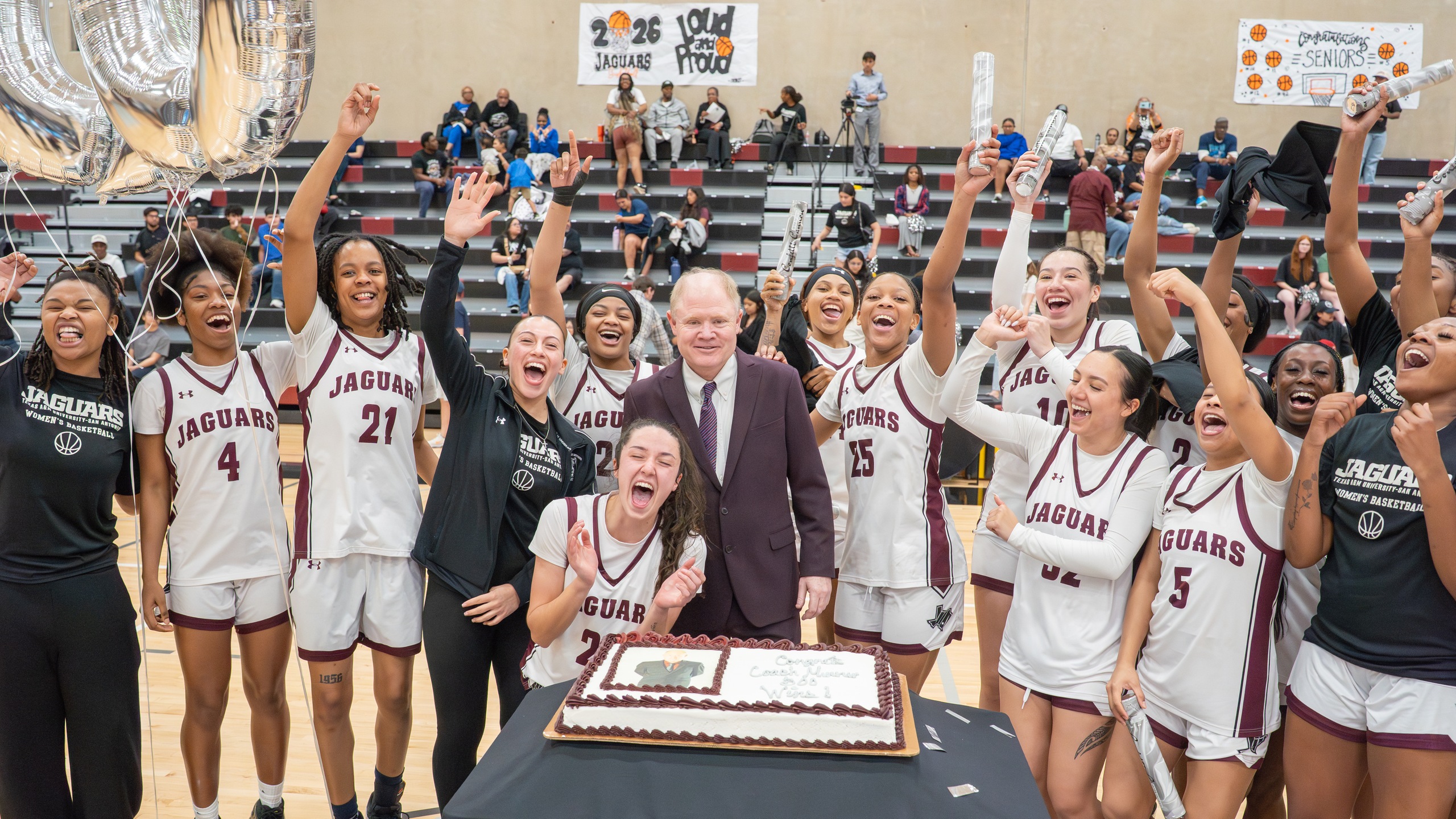 Coach Minner celebrates his 500th win with members of the Jaguar women's basketball team.